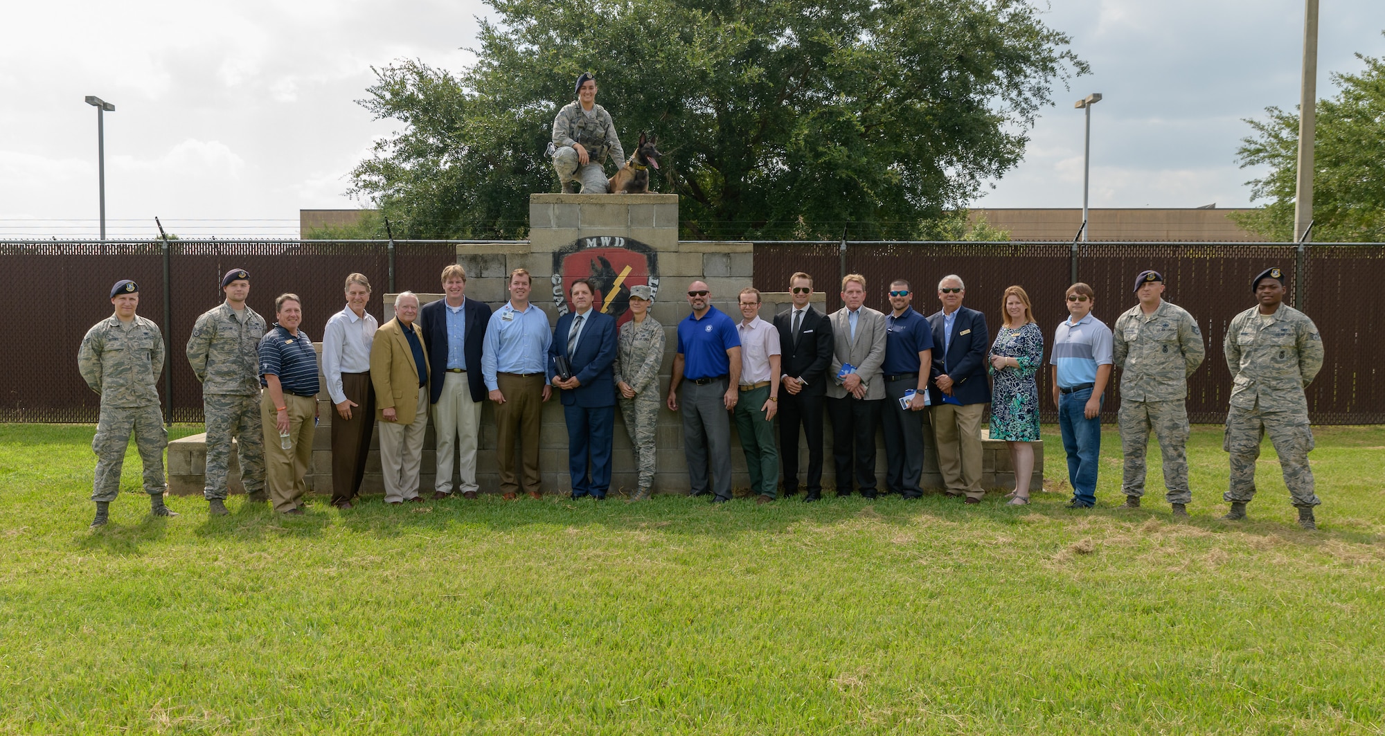 U.S. Air Force Col. Marcia Quigley, 81st Mission Support commander and 81st Security Forces Squadron personnel pose for a group photo with honorary commanders during the 81st Mission Support Group Honorary Commanders tour at the MWD Kennels at Keesler Air Force Base, Mississippi, Aug. 23, 2018. The honorary commander program is a partnership between base leadership and local civic leaders to promote strong ties between military and civilian leaders. (U.S. Air Force Photo by Andre' Askew)