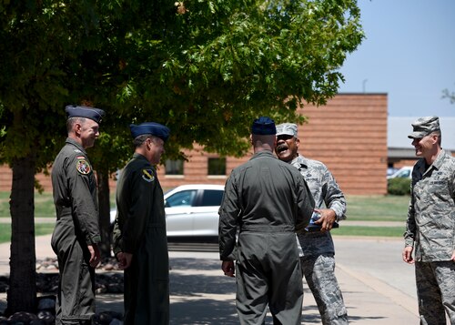 Senior leadership of the 80th FTW and CMSgt. Jack Johnson Jr. share a laugh outside their headquarters building.