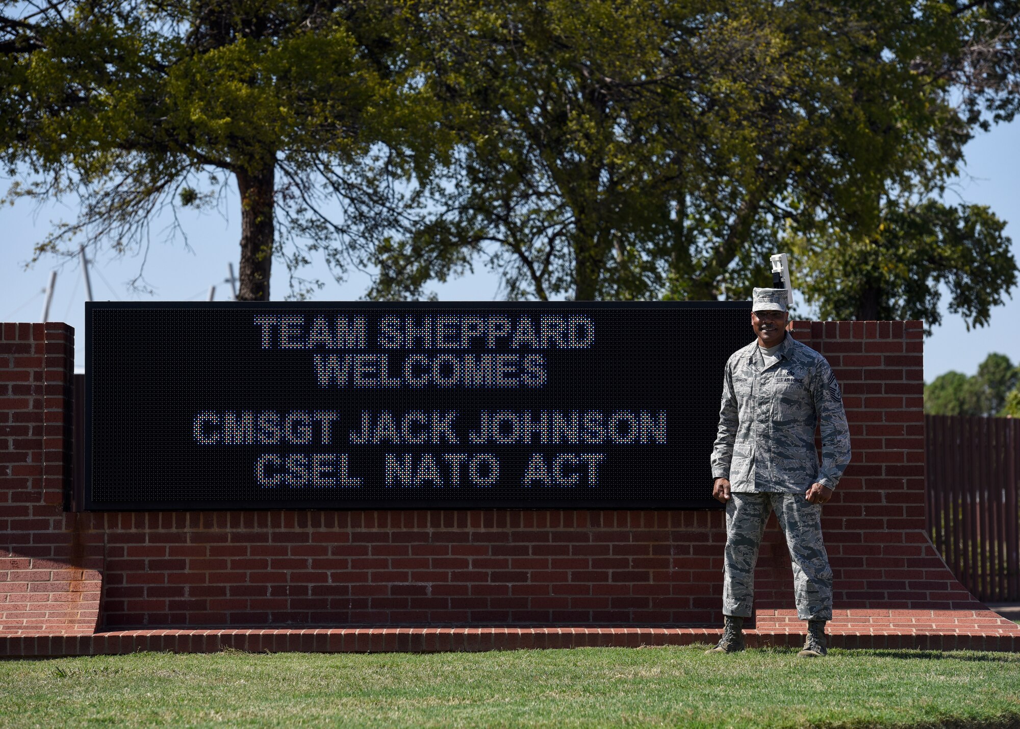 CMSgt. Jack Johnson Jr. stands in front of an electronic welcome sign made for him in front of Sheppard Air Force Base.