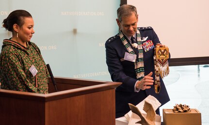 U.S. Air Force Lt. Gen. Ken Wilsbach, commander of Alaskan NORAD Region, Alaskan Command and Eleventh Air Force, accepts a gift from Nicole Borromeo, Alaskan Federation of Natives council member, during a Native Alaska naming ceremony at the Fireweed Convention Center in Anchorage, Alaska, Aug. 21, 2018. AFN hosted the unique event honoring Wilsbach for his service and involvement with Native Alaskan communities during his tenure in Alaska. It marked the first time in Alaska Native history a U.S. Armed forces general officer was given multiple Native names.