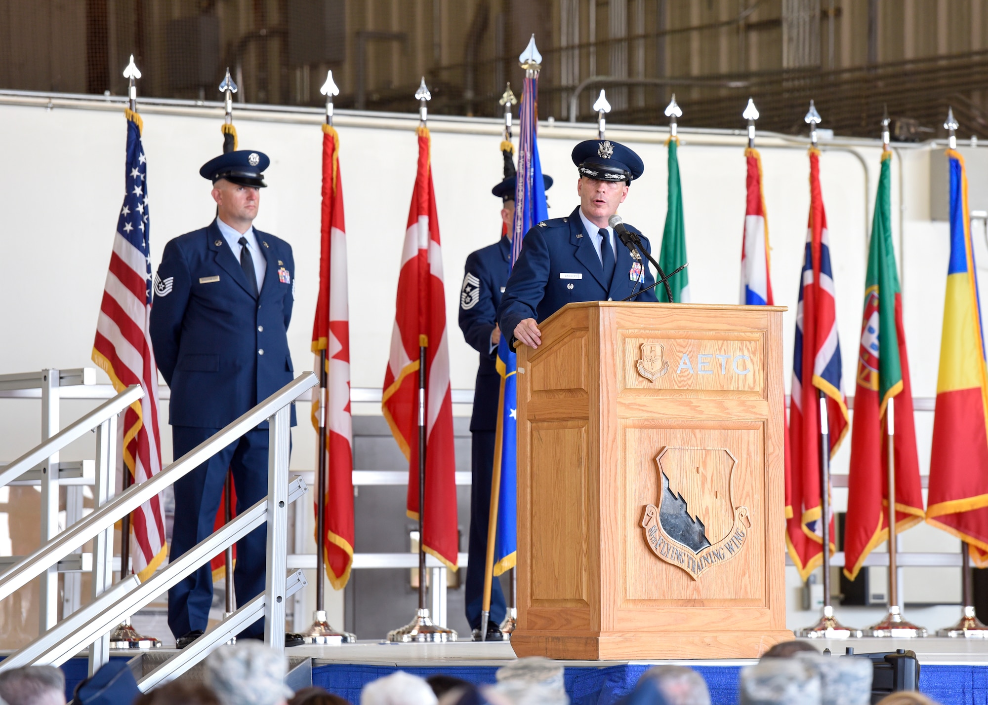 Col. Russell Driggers, 80th Flying Training Wing commander, stands at a podium and gives his first message.
