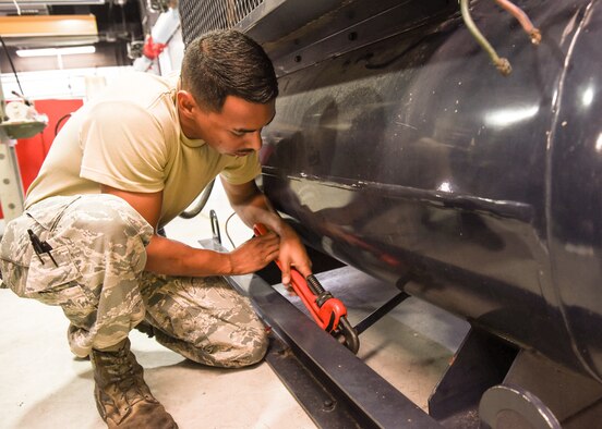 Senior Airman Edgar Pacheco, a powered system support mechanic with the 162nd Maintenance Squadron Aerospace Ground Equipment Flight, turns a wrench on an MB-8 building compressor, as he performs a hydrostatic test on the equipment. The equipment requires this specialized testing every five years, which consists of pumping water into the tank to determine if it can hold pressure.