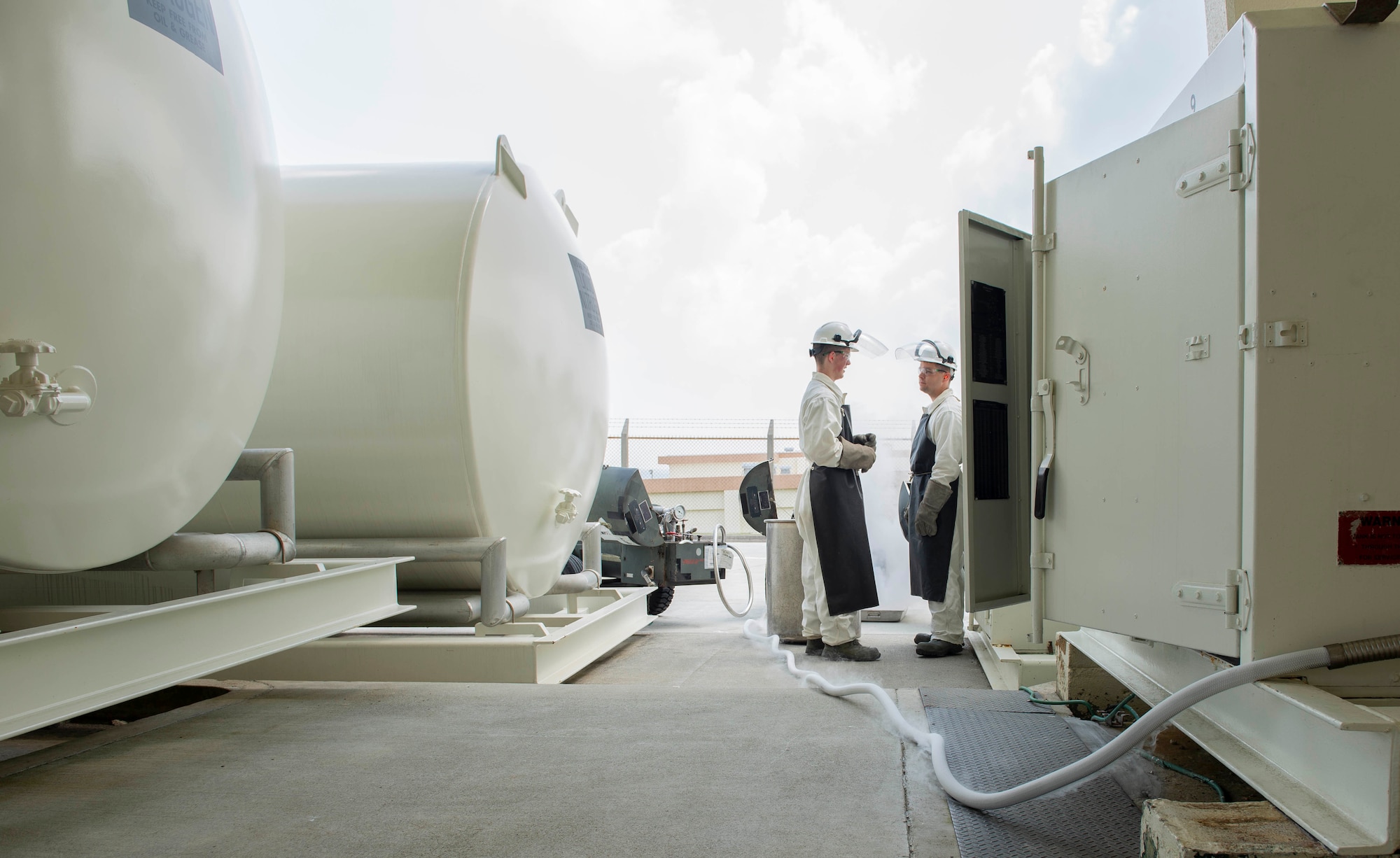 U.S. Air Force Senior Airman Michael Hall and Senior Airman Christopher Tallan, both 18th Logistics Readiness Squadron cryogenic production operators, prepare to fill a cart with liquid oxygen July 27, 2018, at Kadena Air Base, Japan. The production plant provides liquid nitrogen and oxygen to different organizations throughout the island.