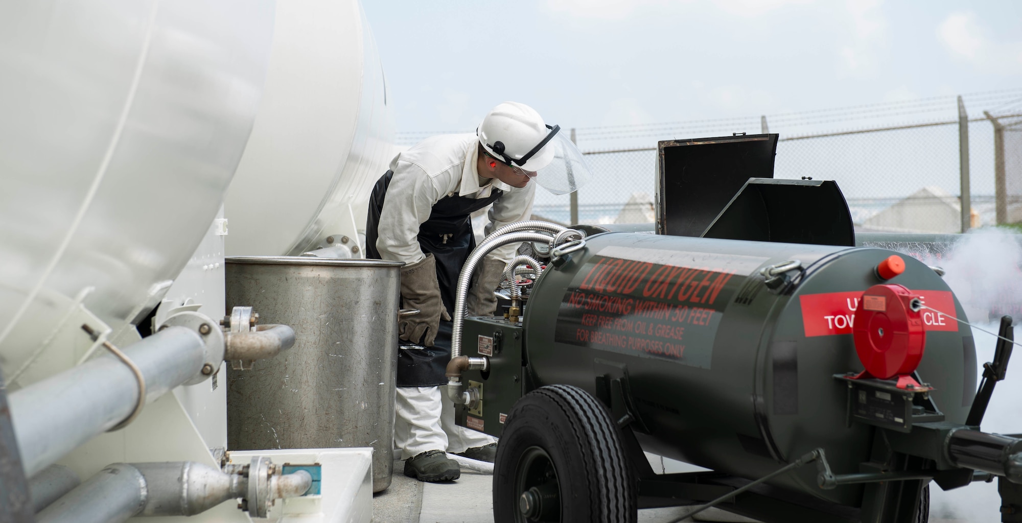 U.S. Air Force Senior Airman Michael Hall, 18th Logistics Readiness Squadron cryogenic production operator, fill a cart with liquid oxygen July 27, 2018, at Kadena Air Base, Japan. The production plant has been operational for nearly a year and has been very successful.