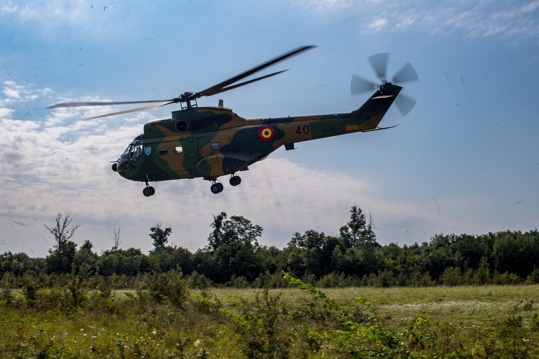 A Romanian air force IAR-330 Puma helicopter takes off after simulating a rescue mission with U.S. Air Force 37th Airlift Squadron pilots during a Survival, Evasion, Rescue, and Escape scenario in Bolovani, Romania, Aug. 24, 2018.