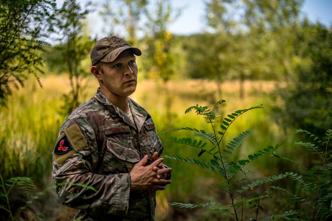 U.S. Air Force Staff Sgt. Christian Martin, 86th Operations Support Squadron Survival, Evasion, Rescue, and Escape specialist, instructs 37th Airlift Squadron pilots on what actions to take during a SERE scenario in Bolovani, Romania, Aug. 24, 2018.