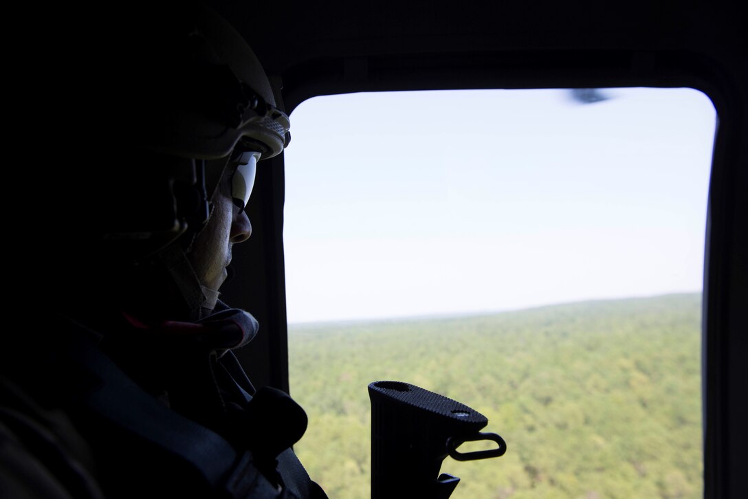 U.S. Air Force Senior Airman Elias Omar, 20th Civil Engineer Squadron explosive ordnance disposal journeyman, looks out the window of a UH-60 Black Hawk helicopter assigned to McEntire Joint National Guard Base, S.C., over Columbia, S.C., Aug. 23, 2018.