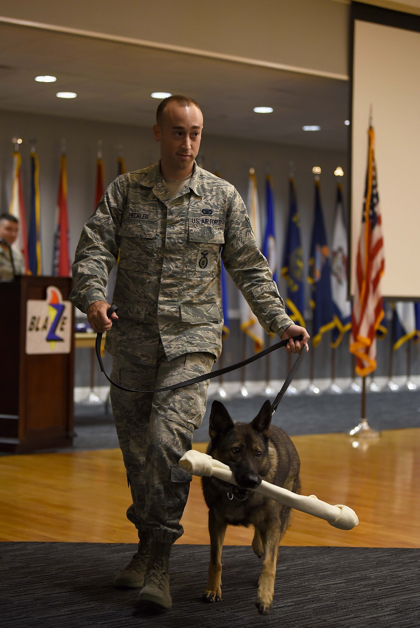 Staff Sgt. Nicholas Heckler, former 14th Security Forces Squadron military working dog handler, walks with newly retired MWD Cherry, during her retirement ceremony Aug. 24, 2018, on Columbus Air Force Base, Mississippi. Cherry retired after serving the Air Force for 10 years Cherry as an explosive detector dog. (U.S. Air Force photo by Airman 1st Class Keith Holcomb)