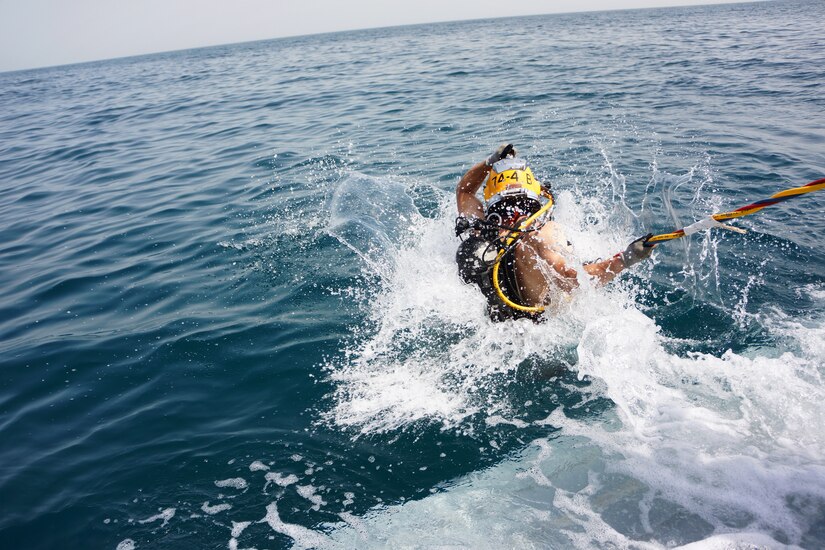 U.S. Army Staff Sgt. Royce Clark, a 1st Class Diving Supervisor of the 74th Dive Detachment, enters the water from LCU 2027 in the Arabian Gulf on July 18, 2018. Clark will simulate a "fouled diver" emergency, requiring decompression and letting the supervisor in charge practice procedures to safely treat the diver.