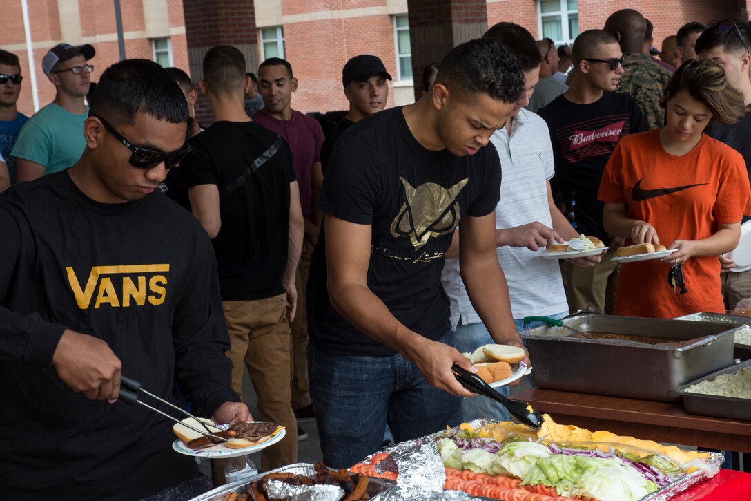 Hungry Marines load their plates during the second annual Headquarters and Headquarters Squadron Barracks Bash at Marine Corps Air Station Cherry Point, N.C., Aug. 24, 2018. Event activities included free food, a volleyball tournament, a beanbag toss tournament, a water pong tournament, basketball and a pie in the face fundraiser. The winners of the tournaments were given a command-authorized 72-hour liberty pass as an award. (U.S. Marine Corps photo by Lance Cpl. Andrew King)