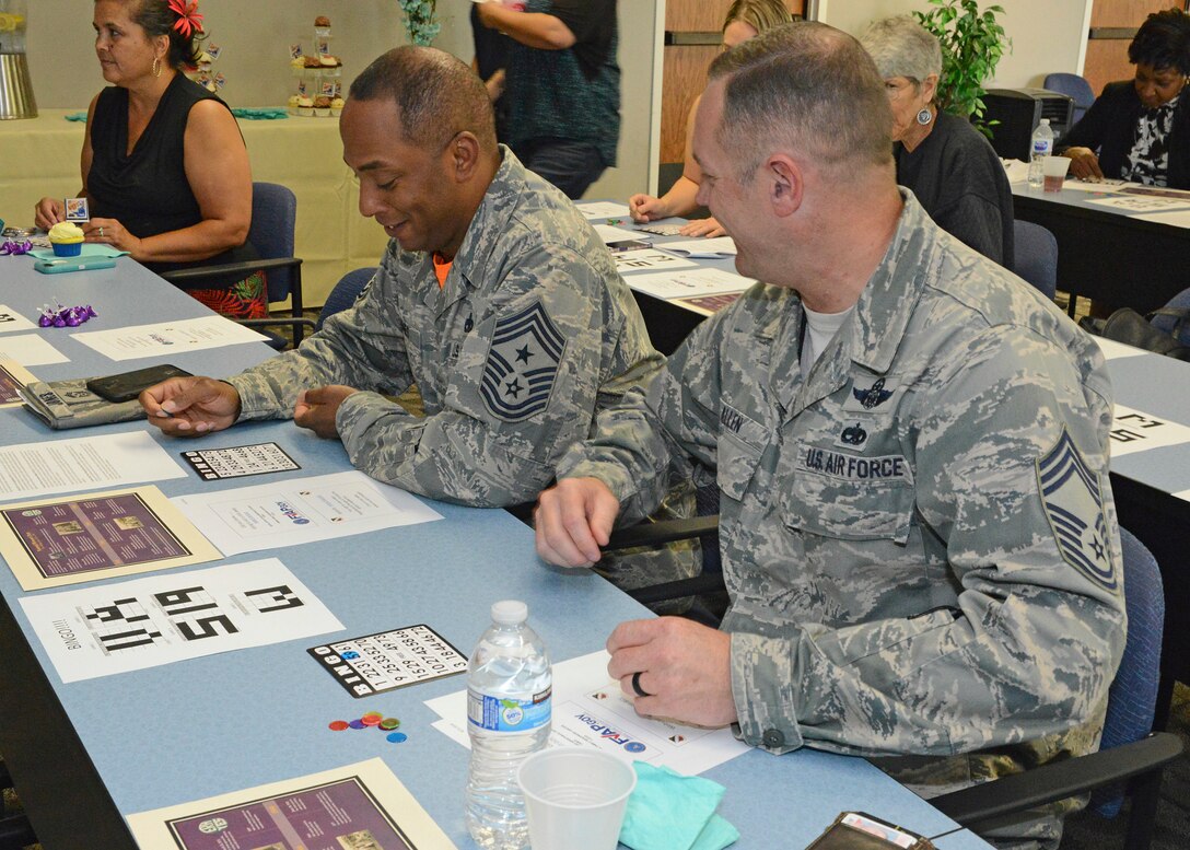 Chief Master Sgt. Roosevelt Jones, 412th Test Wing command chief, and Chief Master Sgt. Marc Allen, 412th Operations Group superintendent, look for matching numbers on their Bingo cards during Edwards AFB’s Women’s Equality Day social held Aug. 24 at the Airman and Family Readiness Center. (U.S. Air Force photo by Kenji Thuloweit)