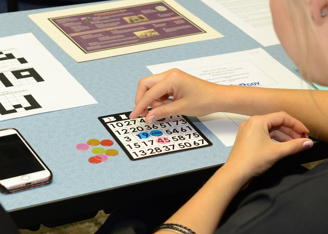 Tech. Sgt. Elizabeth Gould, 412th Logistics Readiness Squadron (left), verifies Staff Sgt. Ciarra Malto’s Bingo win during Edwards AFB’s Women’s Equality Day Social held Aug. 24 at the Airman and Family Readiness Center. Gould helped organize this year’s observance. (U.S. Air Force photo by Kenji Thuloweit)