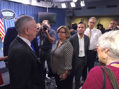 Defense Secretary greets reporters before news conference.