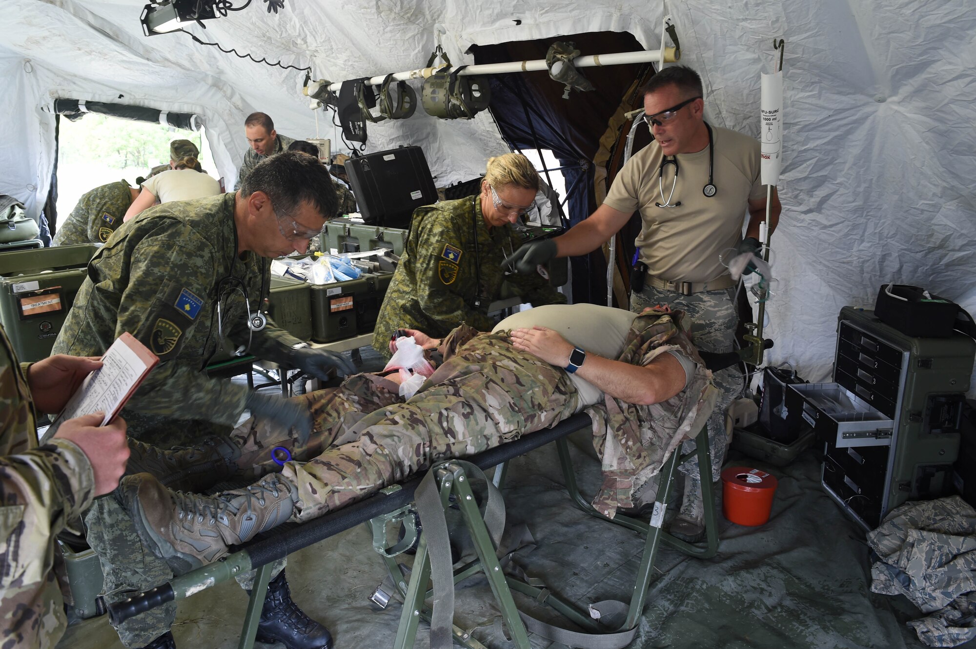 132d MDG Airmen along with Kosovo Security Forces (KSF) medics administer initial treatment August 20, 2018, at Camp Dodge in Johnston, Iowa. The medical team participated in an intensive, two-week, multi-dimensional, medical training course and field training exercise. (U.S. Air National Guard photo by Senior Master Sgt. Robert Shepherd)