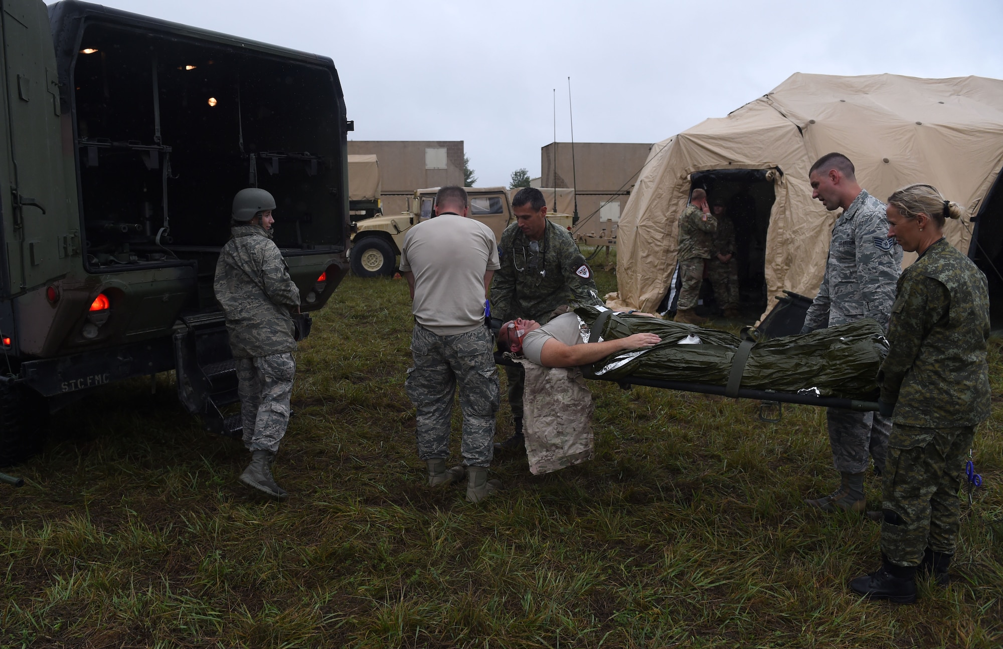 132d MDG Airmen along with Kosovo Security Forces (KSF) medics load a patient into an ambulance August 20, 2018, at Camp Dodge in Johnston, Iowa. The medical team participated in an intensive, two-week, multi-dimensional, medical training course and field training exercise. (U.S. Air National Guard photo by Senior Master Sgt. Robert Shepherd)