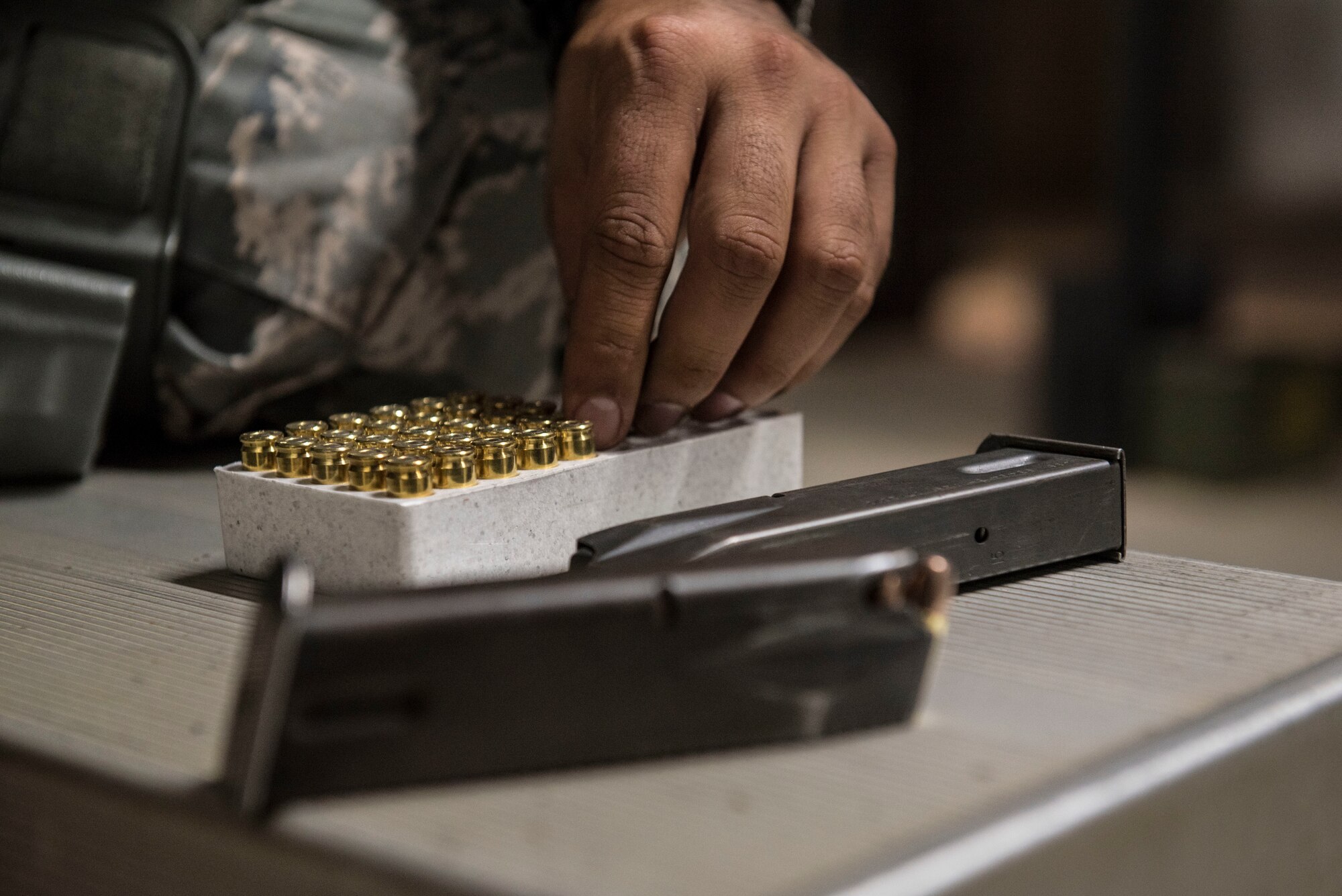 A U.S. Airman grabs a round to load into an M9 pistol magazine at the firing range on Shaw Air Force Base (AFB), S.C., Aug. 22, 2018.