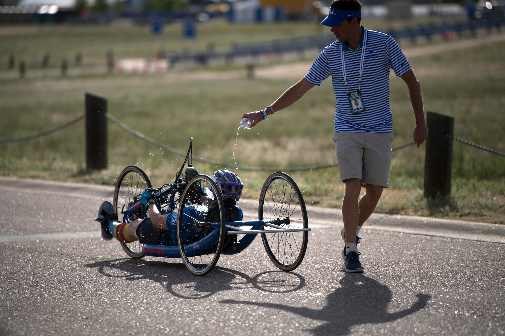 Air Force Coach Aaron Moffett pours water over Master Sgt. Lisa Goad, Team Air Force athlete, during the 2018 DoD Warrior Games cycling competition at the U.S. Air Force Academy in Colorado Springs, Colo. on June 6, 2018. (DoD photo by EJ Hersom)