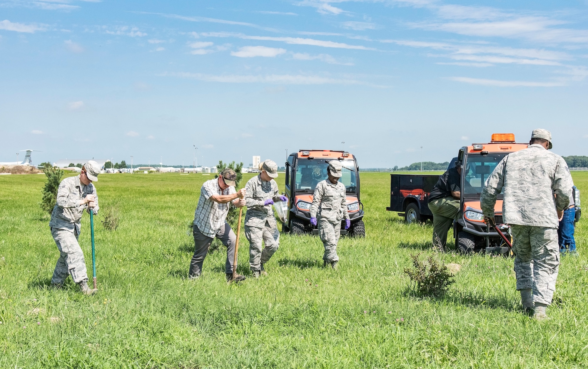 Members comprised of the 436th and 512th Civil Engineer Squadron pest management section prepare to place dead pathogen-infested Japanese beetles in the ground Aug. 9, 2018, on Dover Air Force Base, Del. Approximately 500 infected beetles were buried at five pre-selected locations in the hopes of reducing the population. (U.S. Air Force photo by Roland Balik)