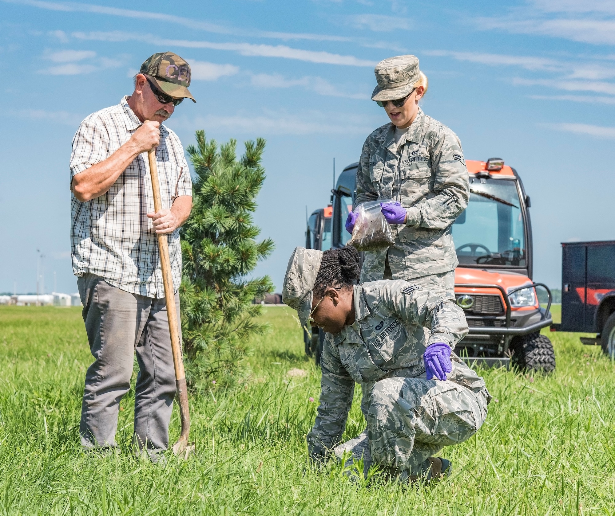 From left, Kevin Barnes, 436th Civil Engineer Squadron pest controller, Senior Airman Alyssa Craig, 512th CES pest management journeyman, and Airman 1st Class Jamie Tstinic, 436th CES pest management journeyman, place dead infested Japanese beetles in the ground Aug. 9, 2018, on Dover Air Force Base, Del. Placement of the beetles was a team effort between active duty and Reserve pest management personnel. (U.S. Air Force photo by Roland Balik)