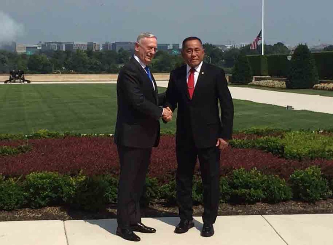 Defense secretary shakes hands with Indonesian defense minister.