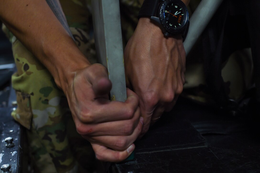 U.S. Air Force Staff Sgt. Raymond Sandoval, 7th Airlift Squadron loadmaster, takes apart seats for paratroopers inside a C-17 Globemaster III during Exercise Predictable Iron at Pope Field, N.C., Aug. 23, 2018. During the exercise, Sandoval and other 62nd Airlift Wing Airmen dropped 40 tons of equipment and 1,005 paratroopers. (U.S. Air Force photo by Senior Airman Tryphena Mayhugh)