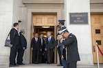 Defense Secretary James N. Mattis walks out of the Pentagon with several officials.