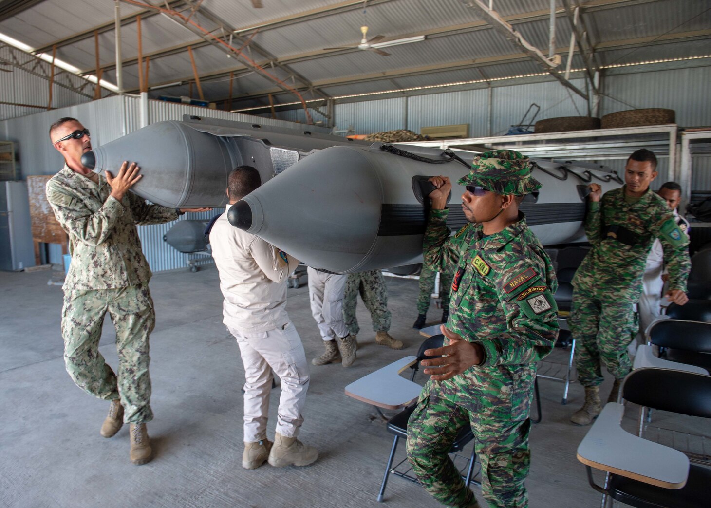 Chief Engineman Rob Hartwell, from Bedford, Massachusetts, assigned to Coastal Riverine Group (CRG) 1 Det. Guam, and members of the Timor-Leste Defense Force and the National Police of Timor-Leste move a personnel transport boat during CARAT Timor-Leste 2018 at Hera Naval Base, Aug. 27, 2018. CRG 1 Det. Guam is assigned to Commander, Task Force (CTF) 75, the primary expeditionary task force responsible for the planning and execution of coastal riverine operations, explosive ordnance disposal, diving engineering and construction, and underwater construction in the U.S. 7th fleet area of operations. CARAT Timor-Leste 2018 is designed to address shared maritime security concerns, build relationships and enhance interoperability among participating forces.