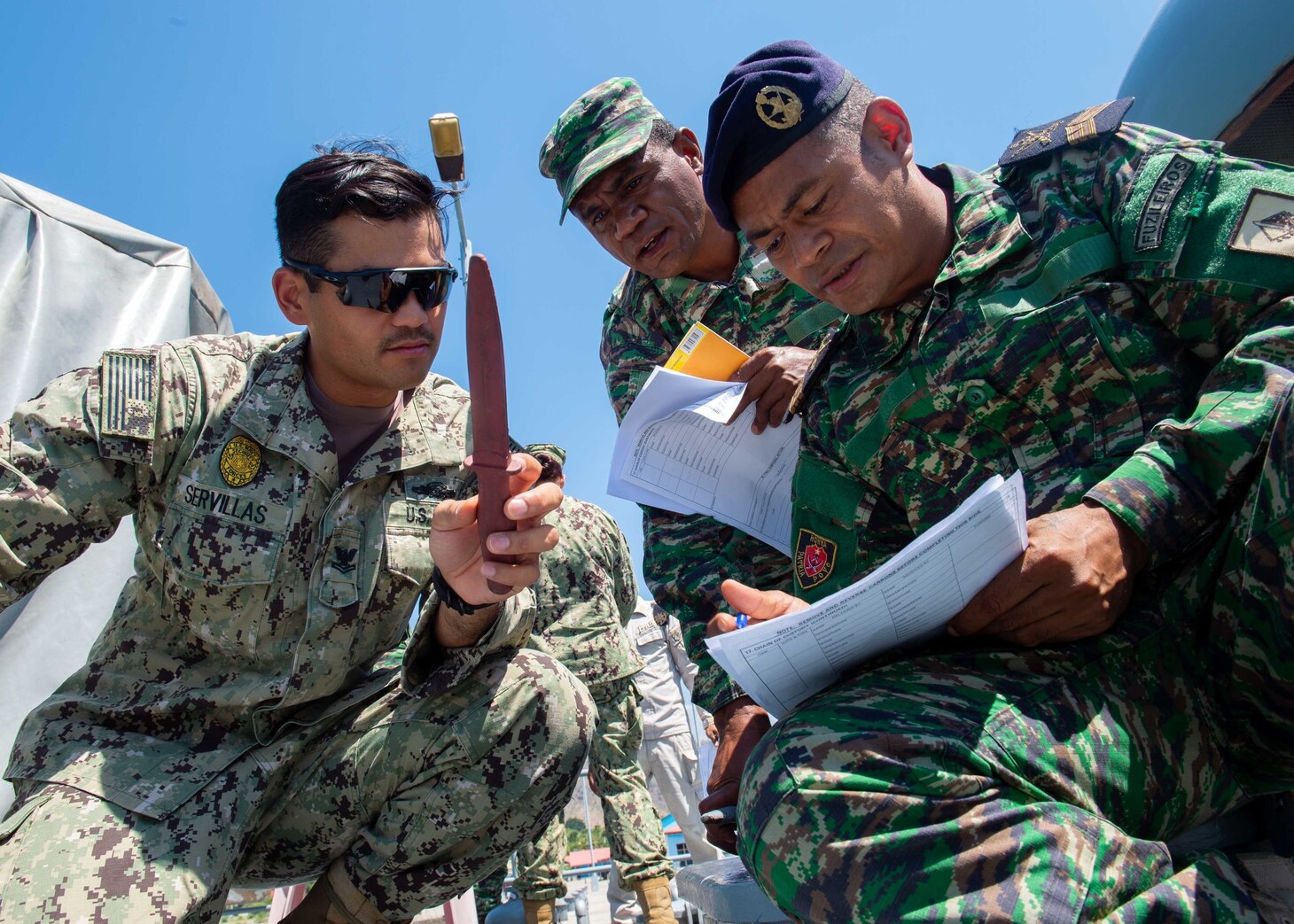 Master-at-Arms 2nd Class Bernard Servillas, from St. Joseph, Michigan, assigned to Coastal Riverine Group (CRG) 1 Det. Guam, and members of the Timor-Leste Defense Force and the National Police of Timor-Leste conduct a briefing on evidence collection and documentation procedures during CARAT Timor-Leste 2018 at Hera Naval Base, Aug. 27, 2018. CARAT Timor-Leste 2018 is designed to address shared maritime security concerns, build relationships and enhance interoperability among participating forces.