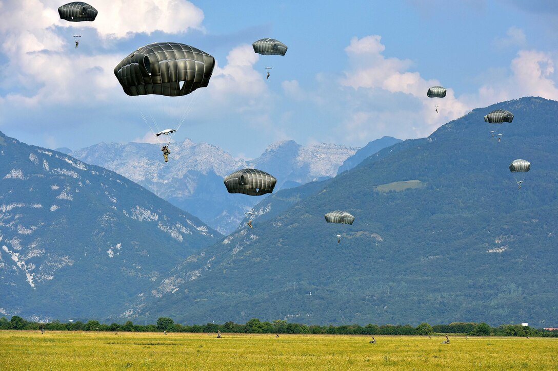 U.S. paratroopers descend with full chutes.