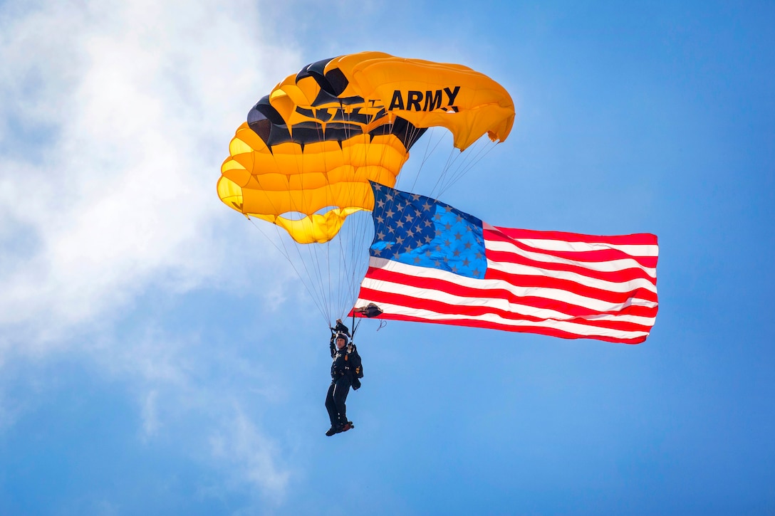 A soldier with the U.S. Army Golden Knights Parachute Team delivers the American flag.