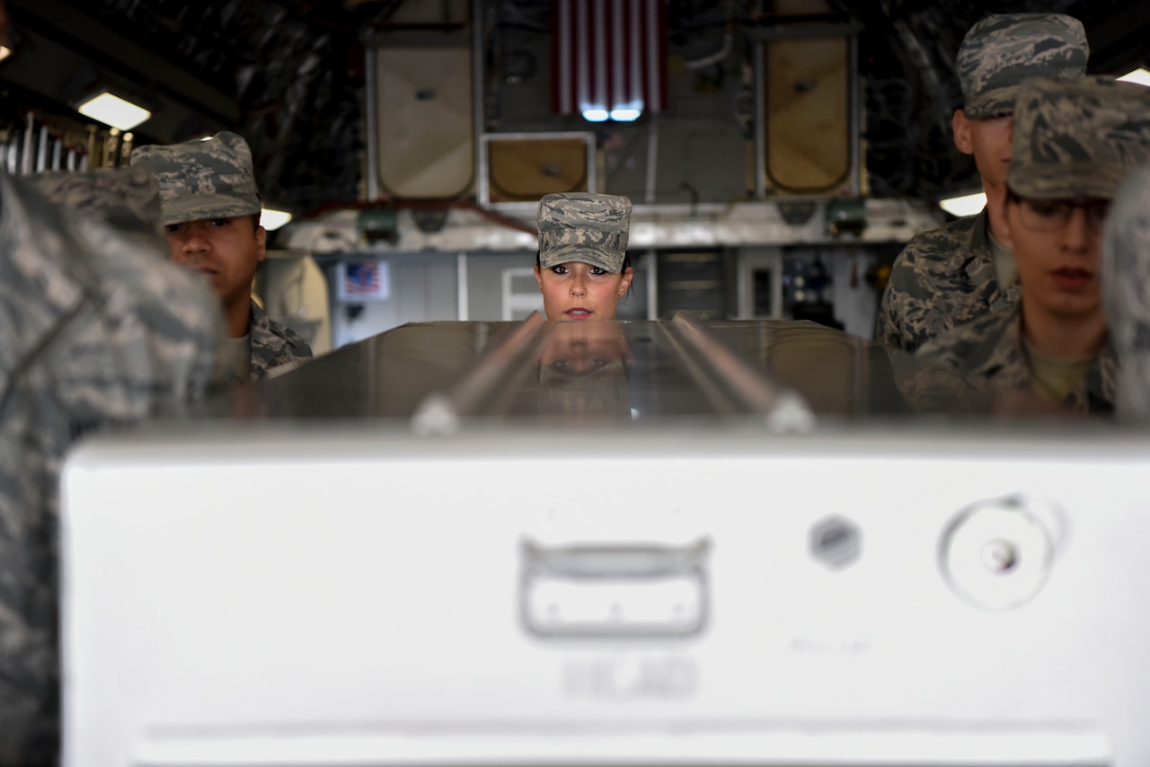 Several airmen flank a casket close up.