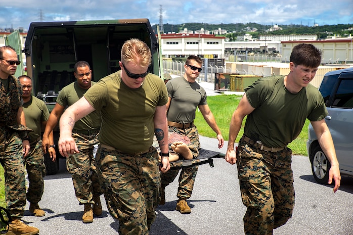 Medical personnel assigned to 3rd Medical Battalion, 3rd Marine Logistics Group, escort a simulated casualty during a Navy Medicine Augmentation Program pre-deployment training at Medical Simulation Training Center South, Okinawa, Japan, Aug. 25, 2018.  Medical personnel with 3rd Med. Bn., 3rd MLG, worked with medical augments to prepare Role II medical facilities. Role II facilities provide a place for injured service members to be received while providing enhanced capabilities such as ultrasound, X-ray and surgery. (U.S. Marine Corps photo by Cpl. Joshua Pinkney)