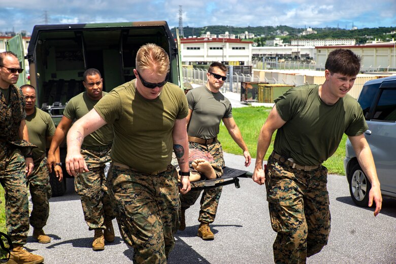 Medical personnel assigned to 3rd Medical Battalion, 3rd Marine Logistics Group, escort a simulated casualty during a Navy Medicine Augmentation Program pre-deployment training at Medical Simulation Training Center South, Okinawa, Japan, Aug. 25, 2018.  Medical personnel with 3rd Med. Bn., 3rd MLG, worked with medical augments to prepare Role II medical facilities. Role II facilities provide a place for injured service members to be received while providing enhanced capabilities such as ultrasound, X-ray and surgery. (U.S. Marine Corps photo by Cpl. Joshua Pinkney)