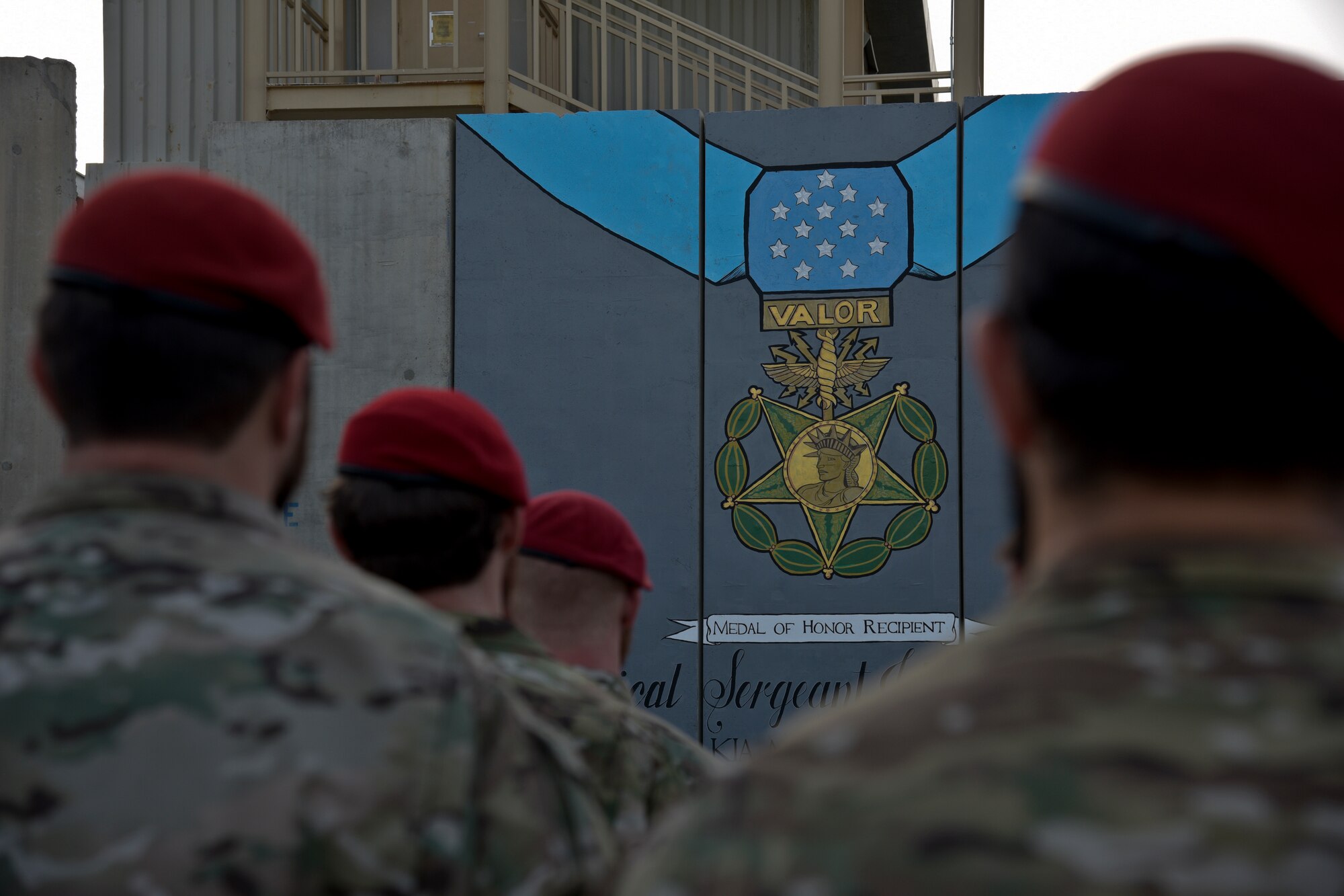 Members of the Special Operations Community gather in front of a mural during the Medal of Honor ceremony for U.S. Air Force Master Sgt. John Chapman on Bagram Airfield, Afghanistan, August 28, 2018. The mural was painted in memory of Chapman for his heroic actions during the Battle of Takur Ghar. (U.S. Air Force photo by Staff Sgt. Kristin High)