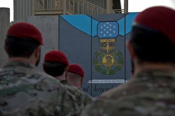 Members of the Special Operations Community gather in front of a mural during the Medal of Honor ceremony for U.S. Air Force Master Sgt. John Chapman on Bagram Airfield, Afghanistan, August 28, 2018. The mural was painted in memory of Chapman for his heroic actions during the Battle of Takur Ghar. (U.S. Air Force photo by Staff Sgt. Kristin High)