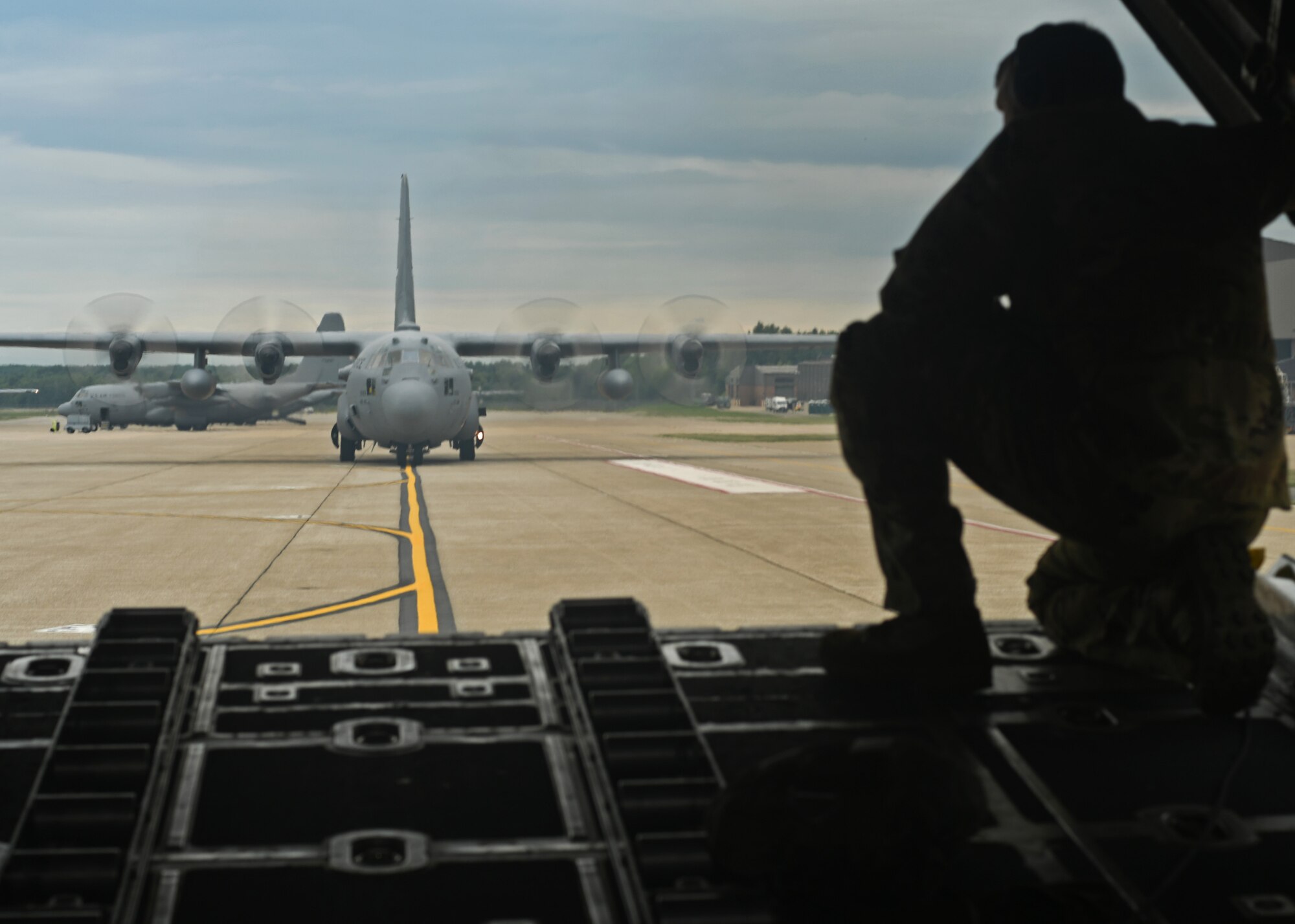 Staff Sgt. Jed Pickett, 700th Aerial Squadron loadmaster, talks with the pilot as a C-130 Hercules backs up on the military ramp at Youngstown Air Reserve Station, Ohio, Aug. 7, 2018. When backing an aircraft, the loadmasters are responsible for directing the pilots by looking out the back of the aircraft and communicating what to do. This is useful to navigate small or congested airfields that don’t have much space, such as those that may be encountered in theater. (U.S. Air Force photo by Staff Sgt. Miles Wilson)