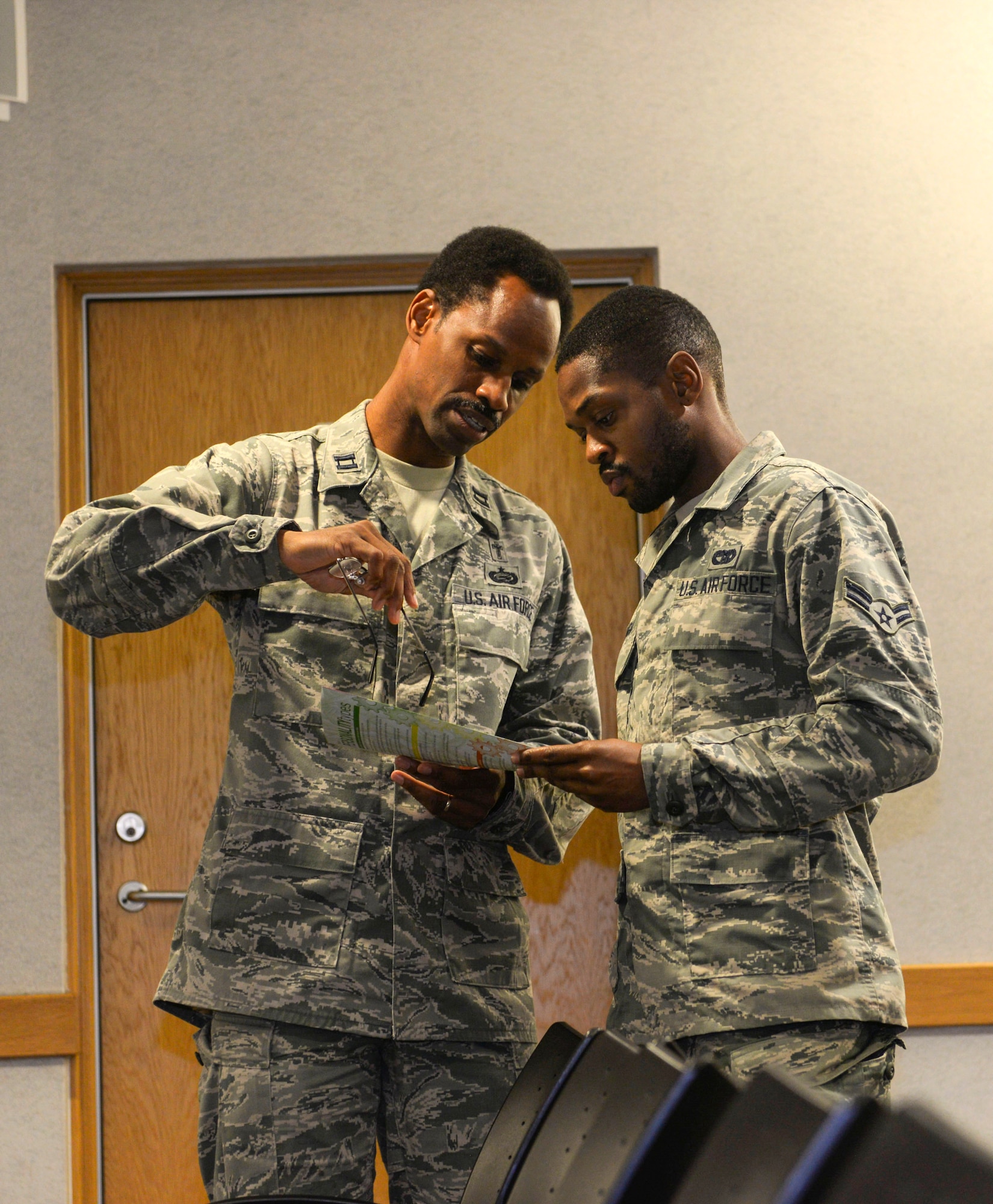 U.S Air Force Chaplain Capt. Kennie Neal, 100th Air Refueling Wing chaplain, and U.S. Air Force Airman 1st Class James Loubeau,  100th Logistics Readiness  vehicle maintenance apprentice, look over a personality test provided by the Young Airmen’s Council to better understand and recognize different personalities at RAF Mildenhall, England, Aug. 22, 2018. The council has hosted several events, including panel discussions. All events are hosted, planned and by Airmen. (U.S. Air Force photo by Airman 1st Class Alexandria Lee)
