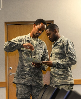 U.S Air Force Chaplain Capt. Kennie Neal, 100th Air Refueling Wing chaplain, and U.S. Air Force Airman 1st Class James Loubeau,  100th Logistics Readiness  vehicle maintenance apprentice, look over a personality test provided by the Young Airmen’s Council to better understand and recognize different personalities at RAF Mildenhall, England, Aug. 22, 2018. The council has hosted several events, including panel discussions. All events are hosted, planned and by Airmen. (U.S. Air Force photo by Airman 1st Class Alexandria Lee)