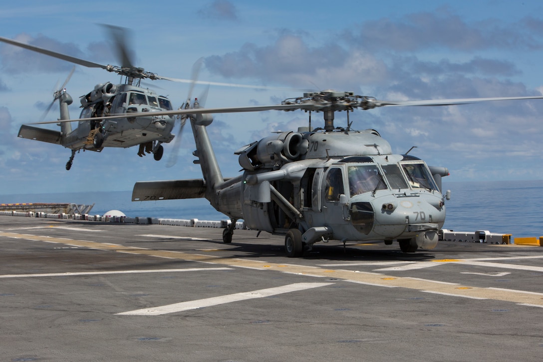 Two MH-60S Seahawks take off from a flight deck of the U.S.S. Kearsarge to observe and conduct a visit, board, search and seizure evolution at sea Aug. 27, 2018. Lt. Gen. Robert F. Hedelund, II Marine Expeditionary Force commanding general, and Vice Adm. Andrew Lewis, commander U.S. 2nd Fleet, were aboard to observe and discuss the joint partnership between II MEF and the 2nd Fleet.