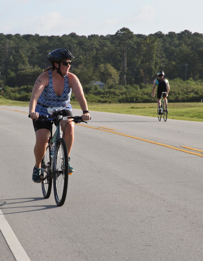 Amy Dozier bikes during the Marine Corps Community Services’ 19th annual Sprint Triathlon Relay at Marine Corps Air Station Cherry Point, N.C., Aug. 18, 2018. Around 80 participants, including services members and their families from the local community and surrounding area, took part in a 400-meter swim, 10-mile bike ride and a 3-mile run. Athletes braved soaring temperatures and stiff competition in the grueling, but popular event. (U.S. Marine Corps photo by Lance Cpl. Alexandra Santos Arambulo)