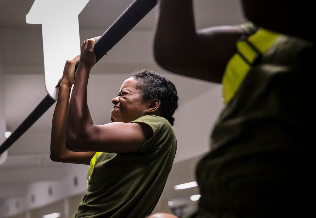 Recruits with Platoon 4038, Papa Company, 4th Recruit Training Battalion, execute pull-ups during their Initial Strength Test on Parris Island July 20, 2018. The minimum physical requirements for female recruits to begin training are 44 crunches in two minutes, 1 pull-up untimed or 15 push ups in two minutes, and a 1.5-mile run in 15 minutes.
