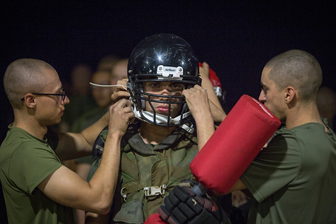 Rct. Jonathan Florentine of Platoon 2060, Echo Company, 2nd Recruit Training Battalion, has his safety gear adjusted by fellow recruits before a pugil sticks bout July 20, 2018, during the Crucible on Parris Island, S.C.