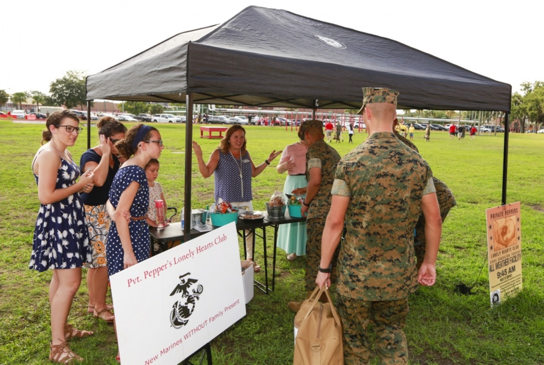Members of Pvt. Pepper’s Lonely Hearts Club welcome Marines from Echo Company, 2nd Recruit Training Battalion to their table for refreshments Aug. 2, 2018. The club provides refreshments and friendly faces to Marines without family or friends on Family Day.