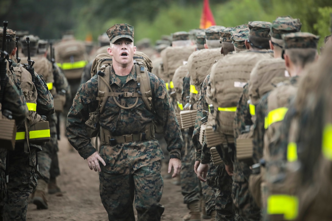 A drill instructor with Mike Company, 3rd Recruit Training Battalion, motivates recruits during a 5K Hike Aug. 25, 2018 on Parris Island, S.C. The recruits, who are in their second week of recruit training, will conduct five hikes of increasing difficulty before the culminating 15K hike after the Crucible.