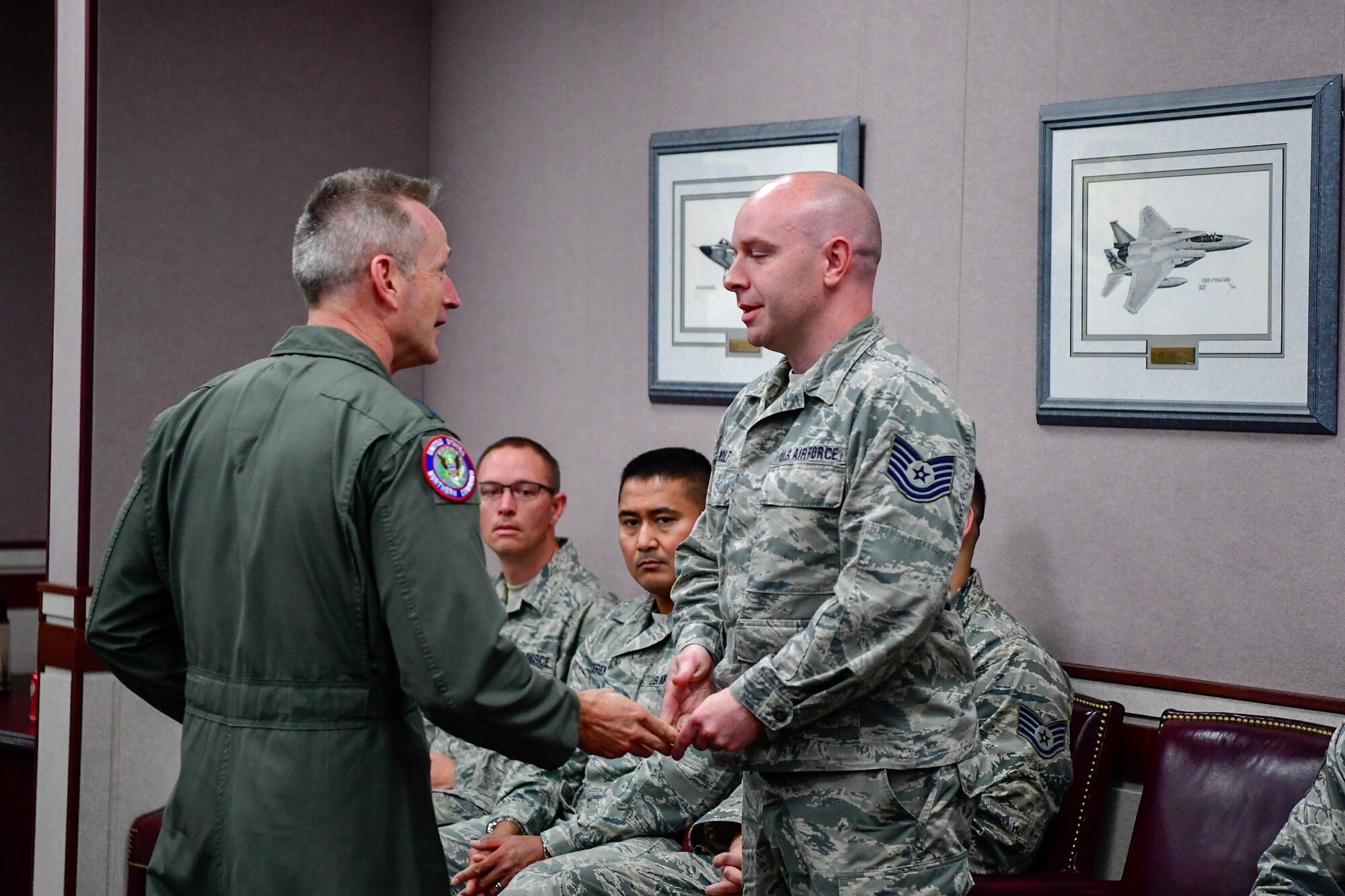 Gen. Terrence O'Shaughnessy, NORAD and USNORTHCOM commander, recognizes Tech. Sgt. Brian Kulp, 225th Air Defense Squadron weapons director, with a commander's coin for the critical role he played during the Aug. 10, 2018 F-15 fighter intercept of the stolen Horizon Bombardier Q400 aircraft out of SeaTac International Airport.  O'Shaughnessy visited the WADS Aug. 23 in order to commend the WADS operations crew for their expert command and control of the 142nd Fighter Wing's F-15 intercept of the stolen aircraft. (U.S. Air National Guard photo by Maj. Kimberly D. Burke)