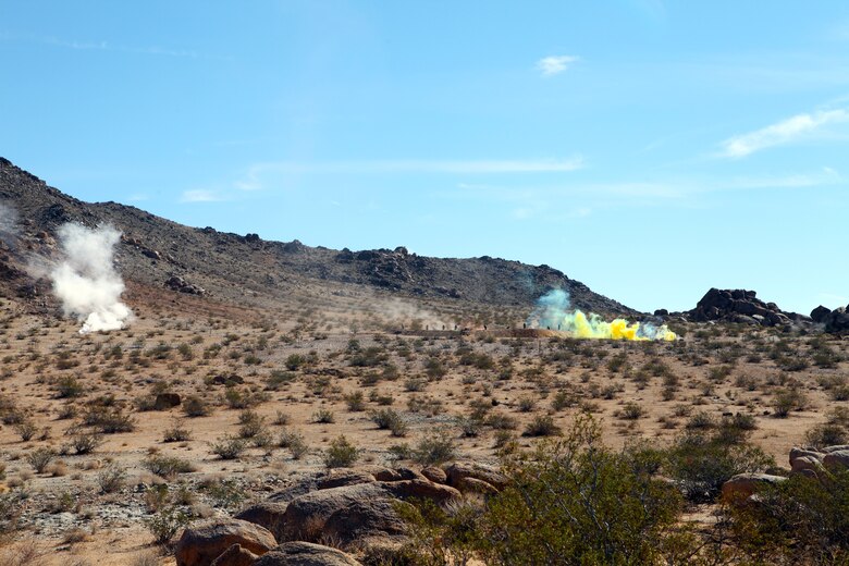 Plumes of white and yellow smoke provide cover for members of India Company, 3rd Battalion, 4th Marines, 7th Marine Regiment, as they advance during live-fire training in the Galway Lake Training Area in the Johnson Valley Exclusive Military Use Area, Marine Corps Air Ground Combat Center, Twentynine Palms, Calif., Aug. 24, 2018. (Marine Corps photo by Kelly O'Sullivan)