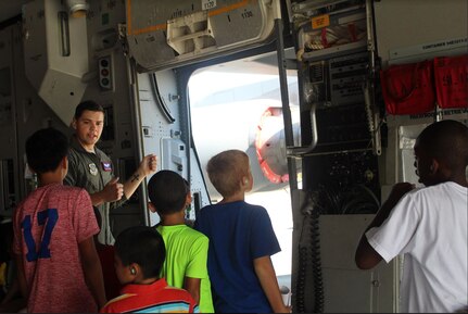 Airman 1st Class Garrett Lisenby, 15th Airlift Squadron loadmaster, explains how airdropping personnel out the troop doors works during an Aug. 10, 2018, STEMspiration camp visit to Joint Base Charleston, S.C.  The camp is sponsored by the Charleston County School District.