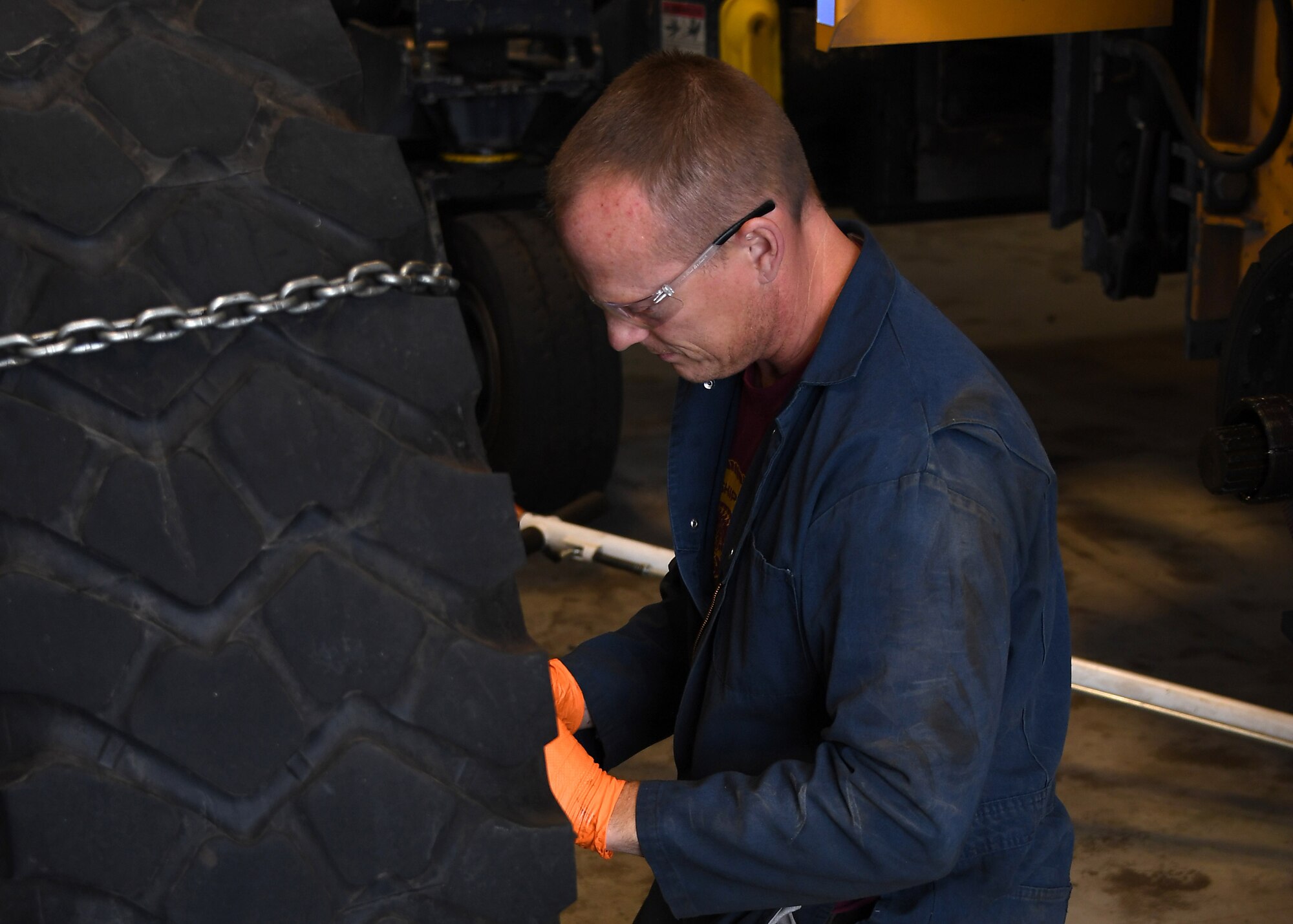 Paul Holien, 319th Logistics Readiness Squadron heavy equipment mobile mechanic, inspects a removed tire belonging to a large snow plow August 28, 2018, on Grand Forks Air Force Base, North Dakota. In addition to snow plows, the 319 LRS also maintains vehicles to include fire trucks, aerial lift trucks and additional government vehicles utilized by other squadrons around base. (U.S. Air Force photo by Airman 1st Class Elora J. Martinez)