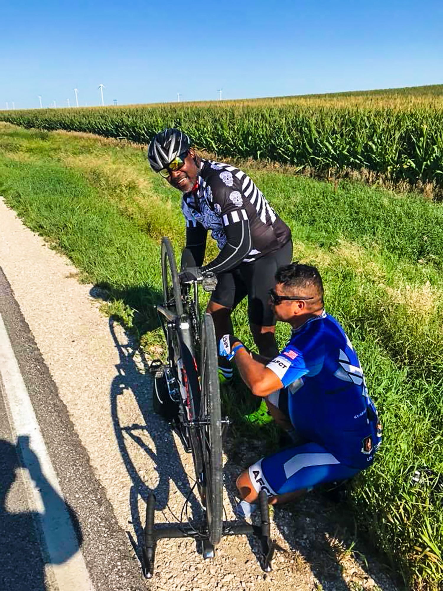 Air Force Cycling Team's Master Sgt. Miguel Duarte Hernandez, stationed at Hill Air Force Base, Utah, assists a rider with a bicycle repair along the more than 500-mile route of the Register's Great Bicycle Ride Across Iowa that took place July 22-28, 2018.