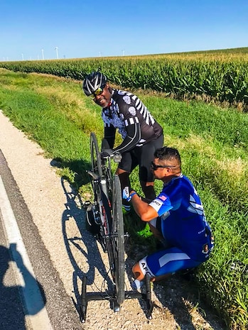Air Force Cycling Team's Master Sgt. Miguel Duarte Hernandez, stationed at Hill Air Force Base, Utah, assists a rider with a bicycle repair along the more than 500-mile route of the Register's Great Bicycle Ride Across Iowa that took place July 22-28, 2018.